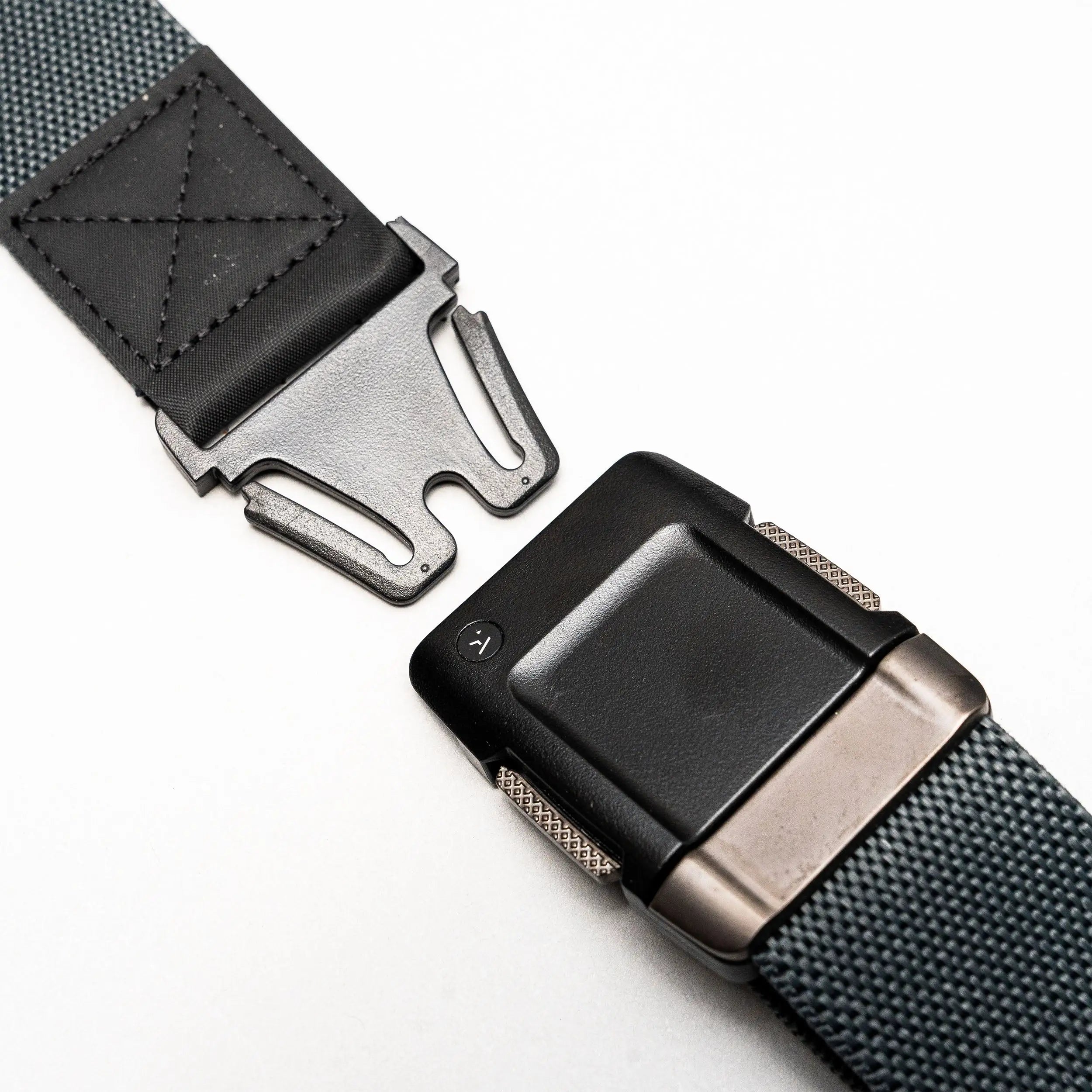 A close-up of the Arcade Belts Motion, a gray performance stretch belt featuring a black and metal quick-release buckle, shown partially unfastened on a white background for a comfortable fit.