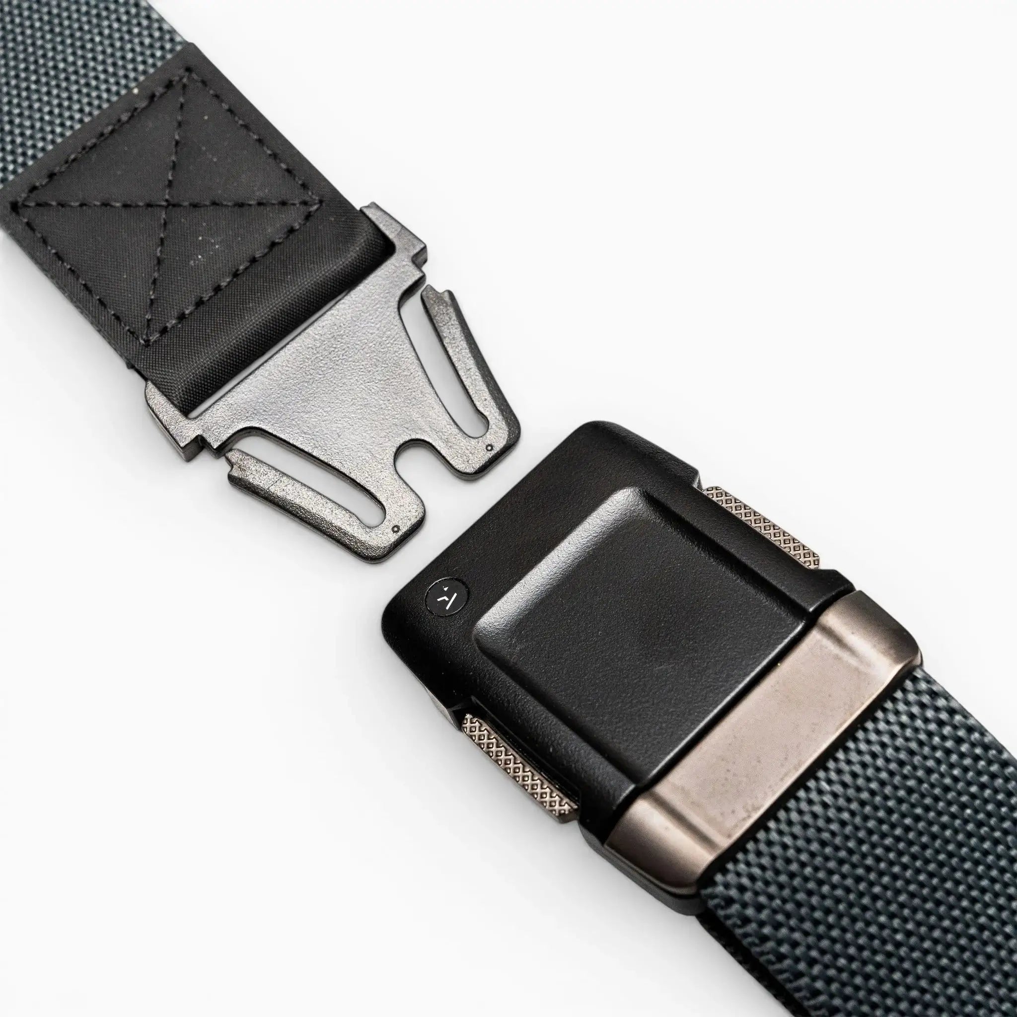 A close-up of the Arcade Belts Motion, a gray performance stretch belt featuring a black and metal quick-release buckle, shown partially unfastened on a white background for a comfortable fit.