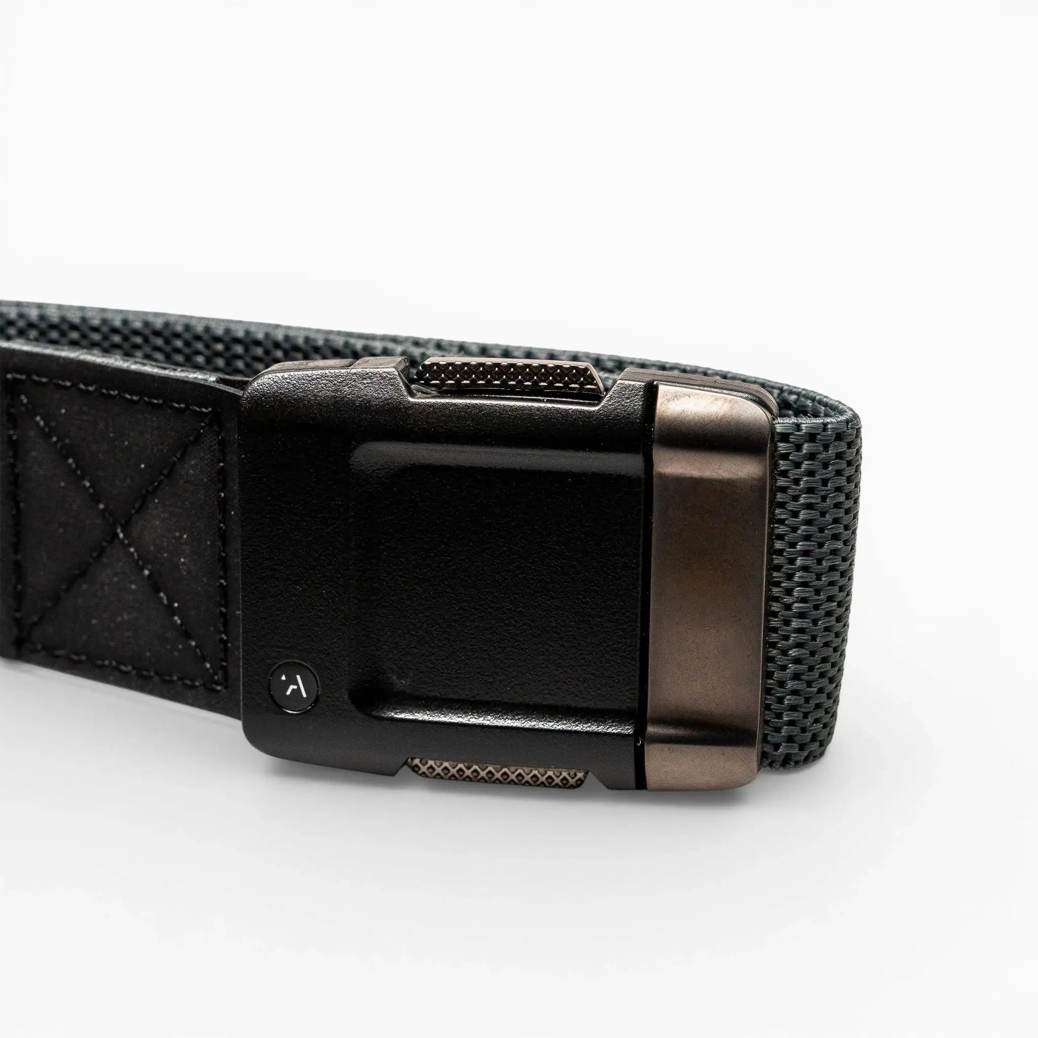 A close-up of the Arcade Belts Motion, a gray performance stretch belt with a black and metallic rectangular buckle, highlights its comfortable fit and modern style on a light background.