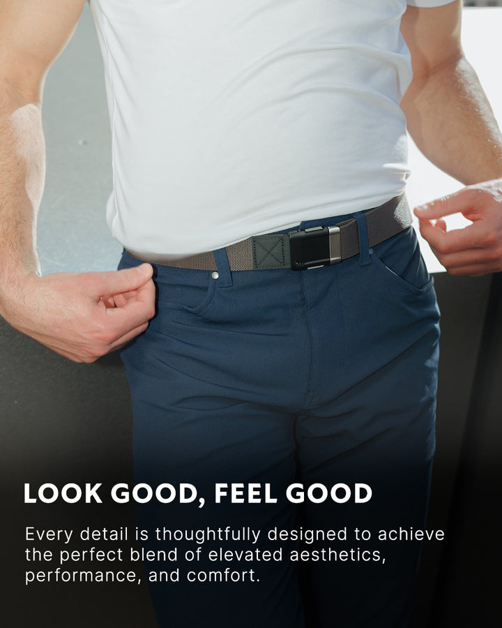 A person wearing a white shirt and blue pants adjusts a gray Arcade Belt with a plastic buckle. Text reads: LOOK GOOD, FEEL GOOD. Every detail is thoughtfully designed for elevated aesthetics, performance, and comfort.
