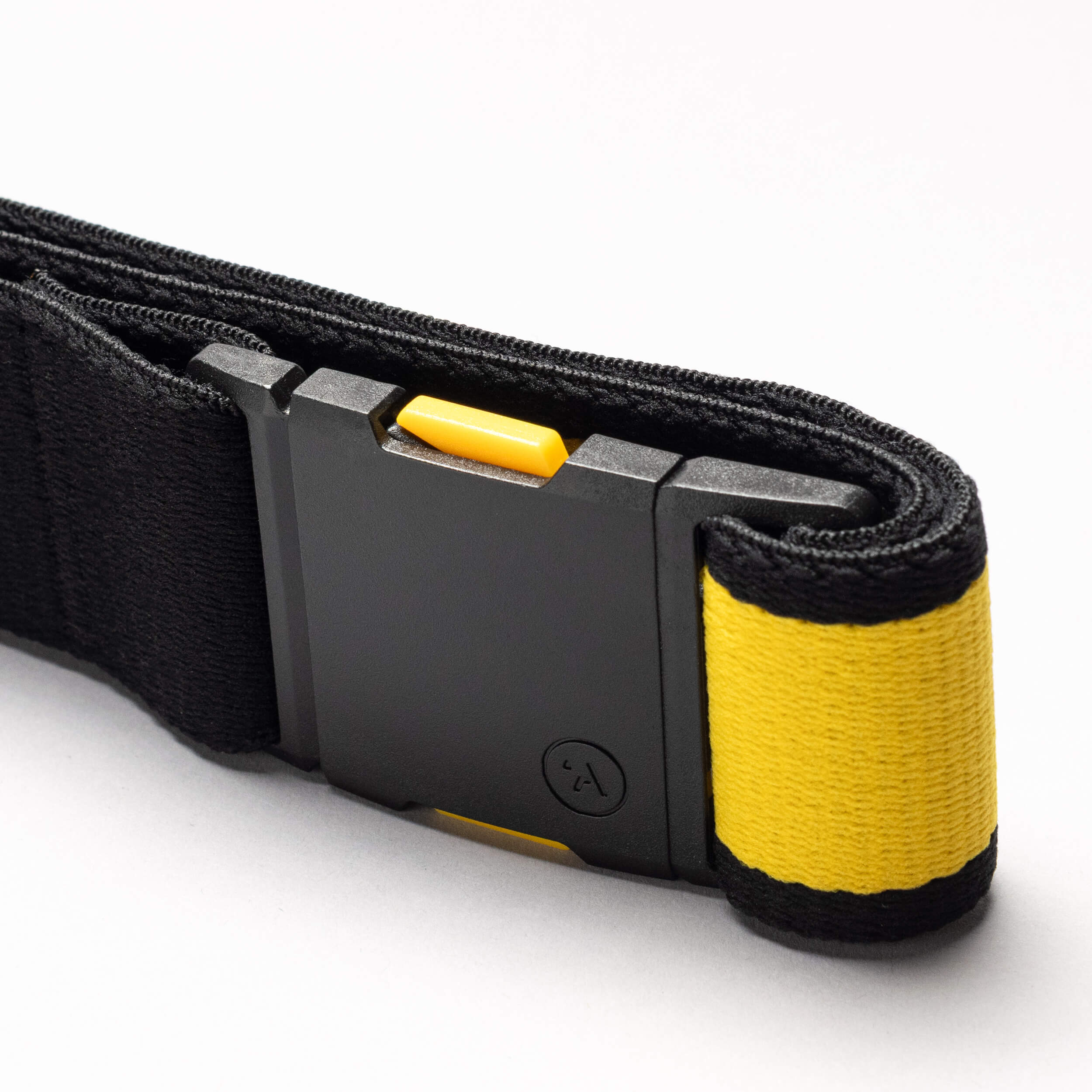 A close-up of the Arcade Belts National Geographic strap: black with a black plastic buckle, yellow accent, and yellow fabric-wrapped end with a black stripe. Features a distinctive yellow button release—ideal for adventures.
