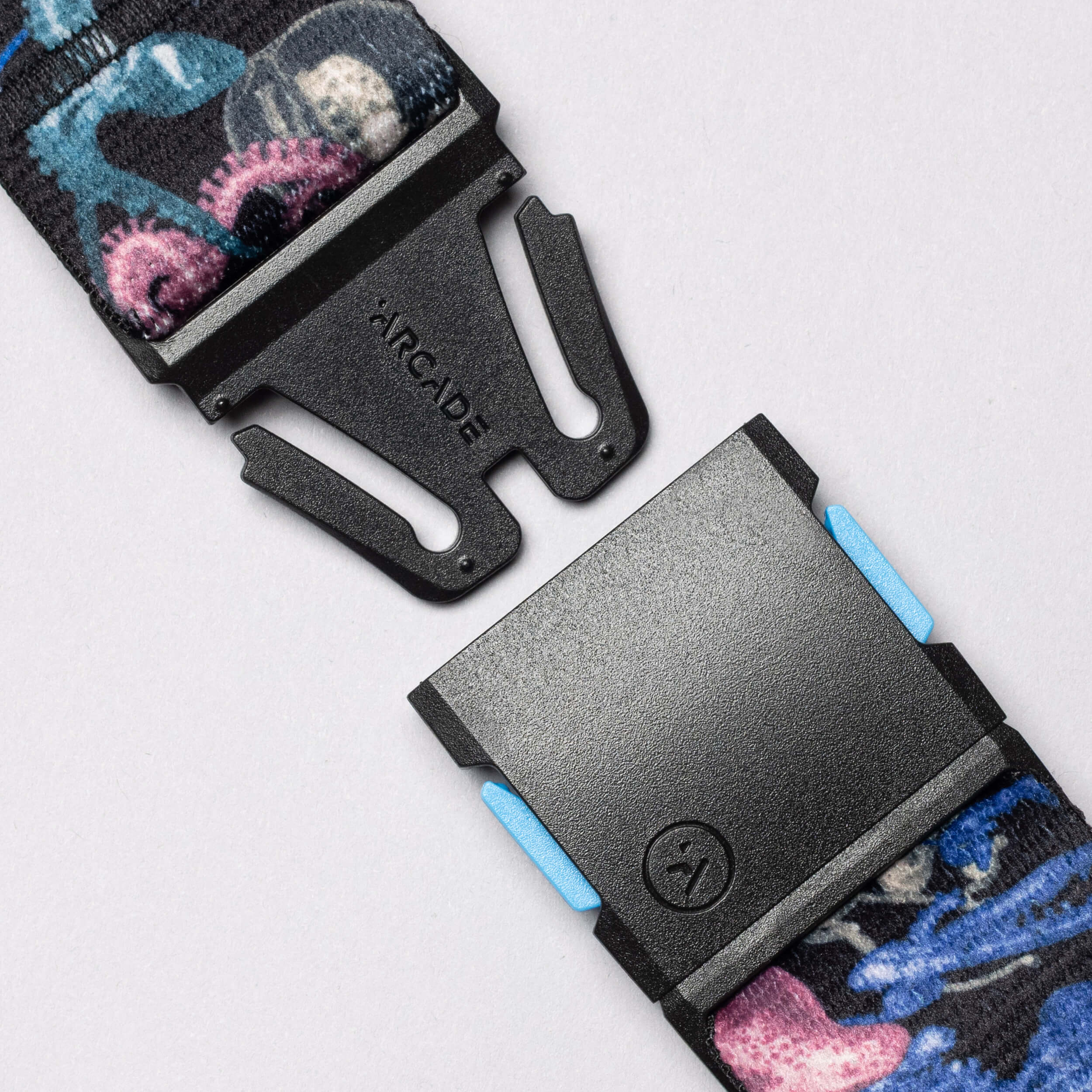 The Arcade Belts National Geographic features blue and pink straps on a black belt, ideal for daily adventures or accessorizing as you share inspirational stories.