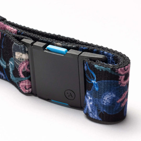 A close-up of the National Geographic belt by Arcade Belts, featuring a black rectangular plastic buckle and a blue and pink floral patterned strap—ideal for everyday adventures.