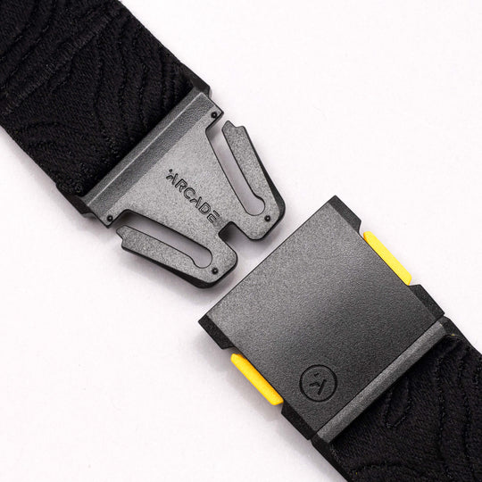 Close-up of the National Geographic by Arcade Belts buckle with a secure, interlocking design and subtle yellow accents on a white background—ideal for those wanting a modern Low Profile Belt.