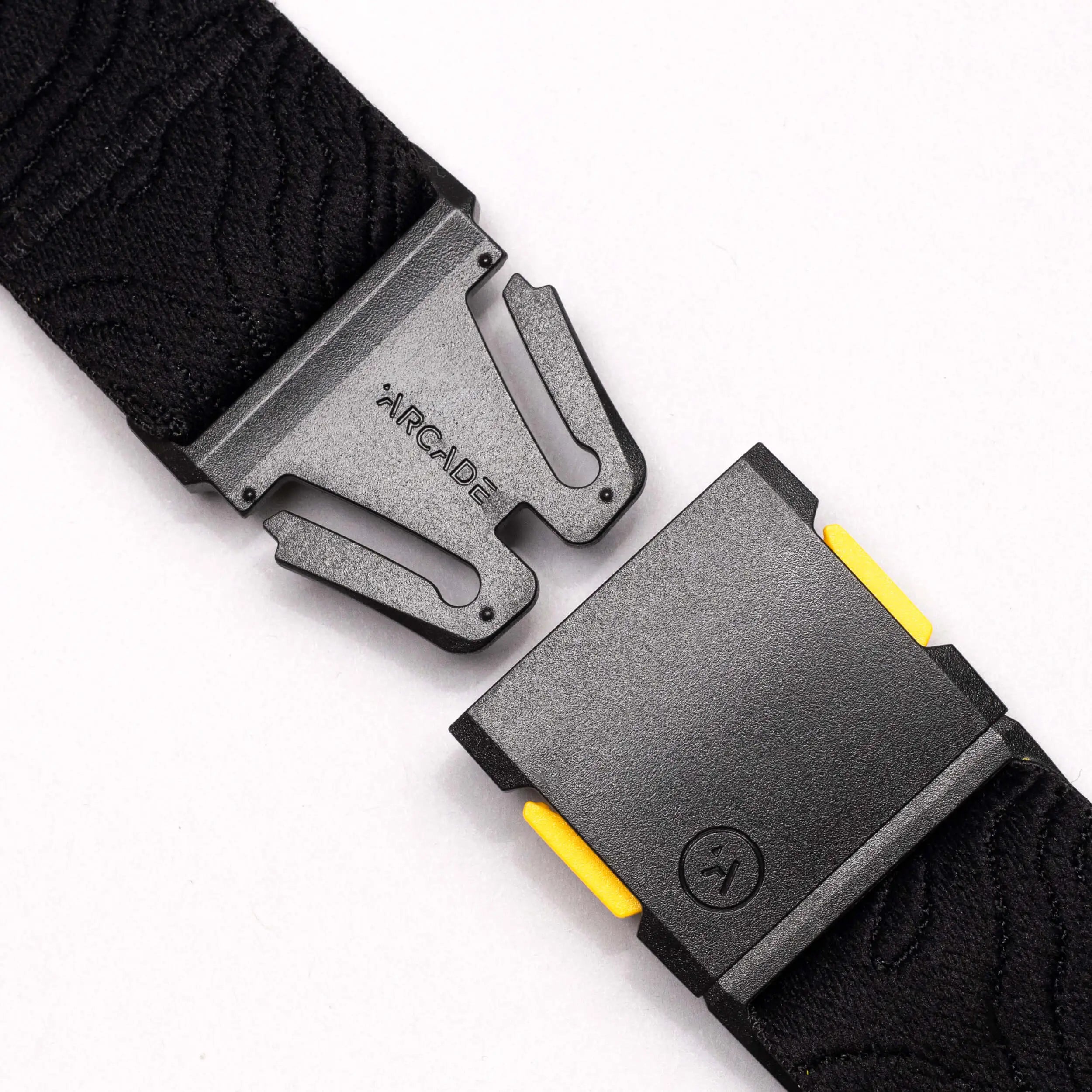 Close-up of the National Geographic by Arcade Belts buckle with a secure, interlocking design and subtle yellow accents on a white background—ideal for those wanting a modern Low Profile Belt.