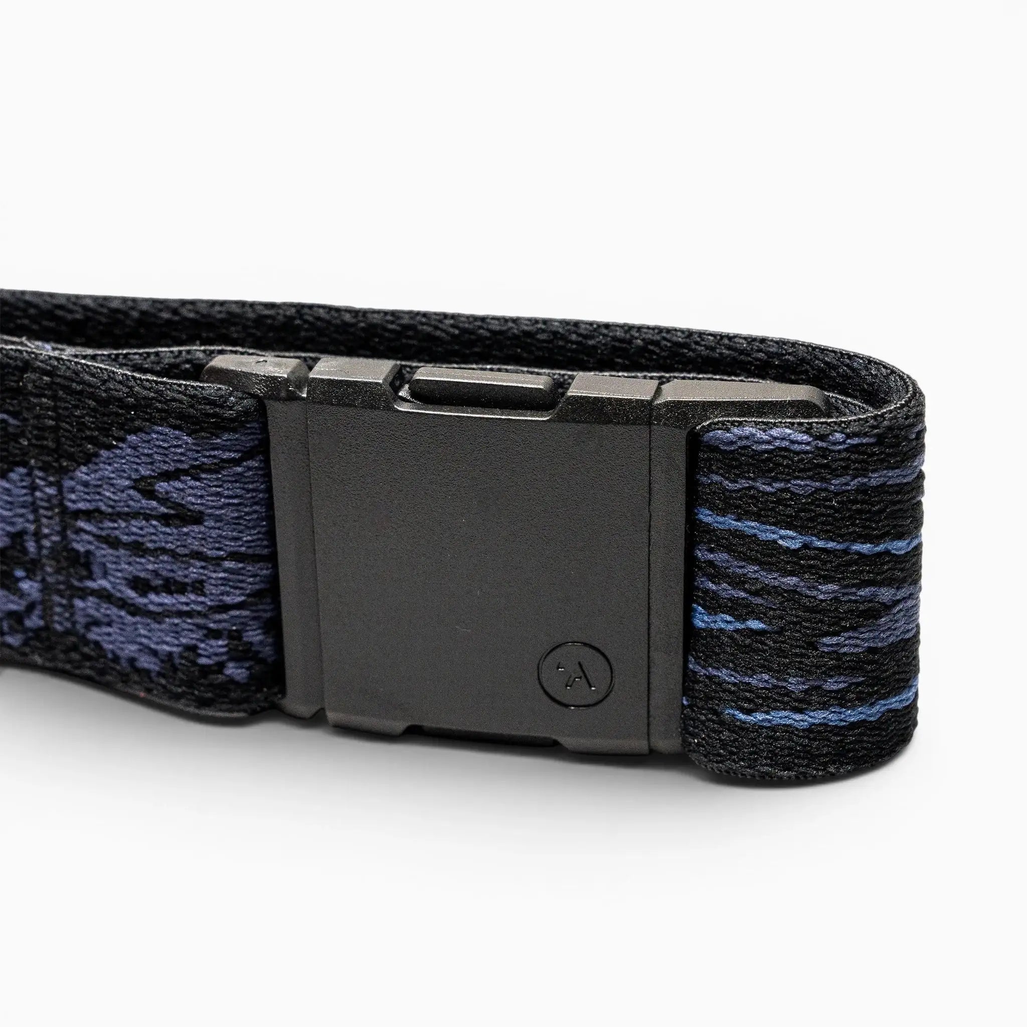 A close-up of the Arcade Belts Out of Range black plastic buckle on an elastic stretch belt with a dark blue and black patterned strap, shown against a white background.