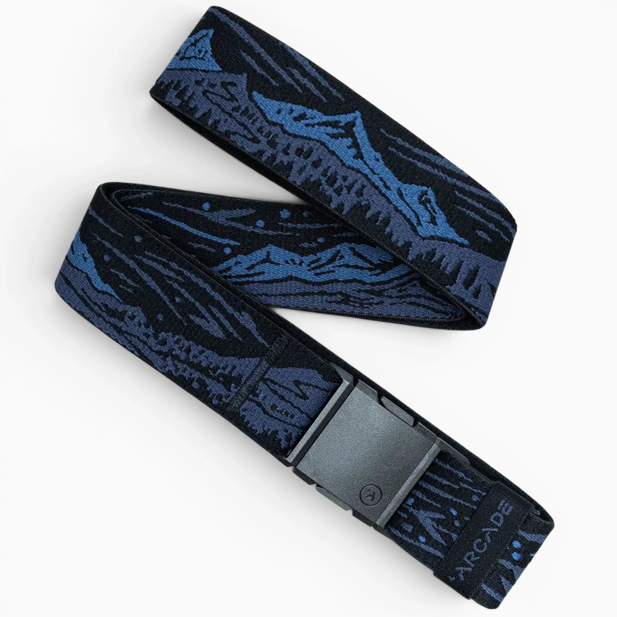 The Arcade Belts Out of Range is a dark blue and black belt with a mountain landscape design, made from stretch webbing for comfort. It features a black plastic buckle and the Arcade logo near the buckle, laid out in a zigzag pattern.