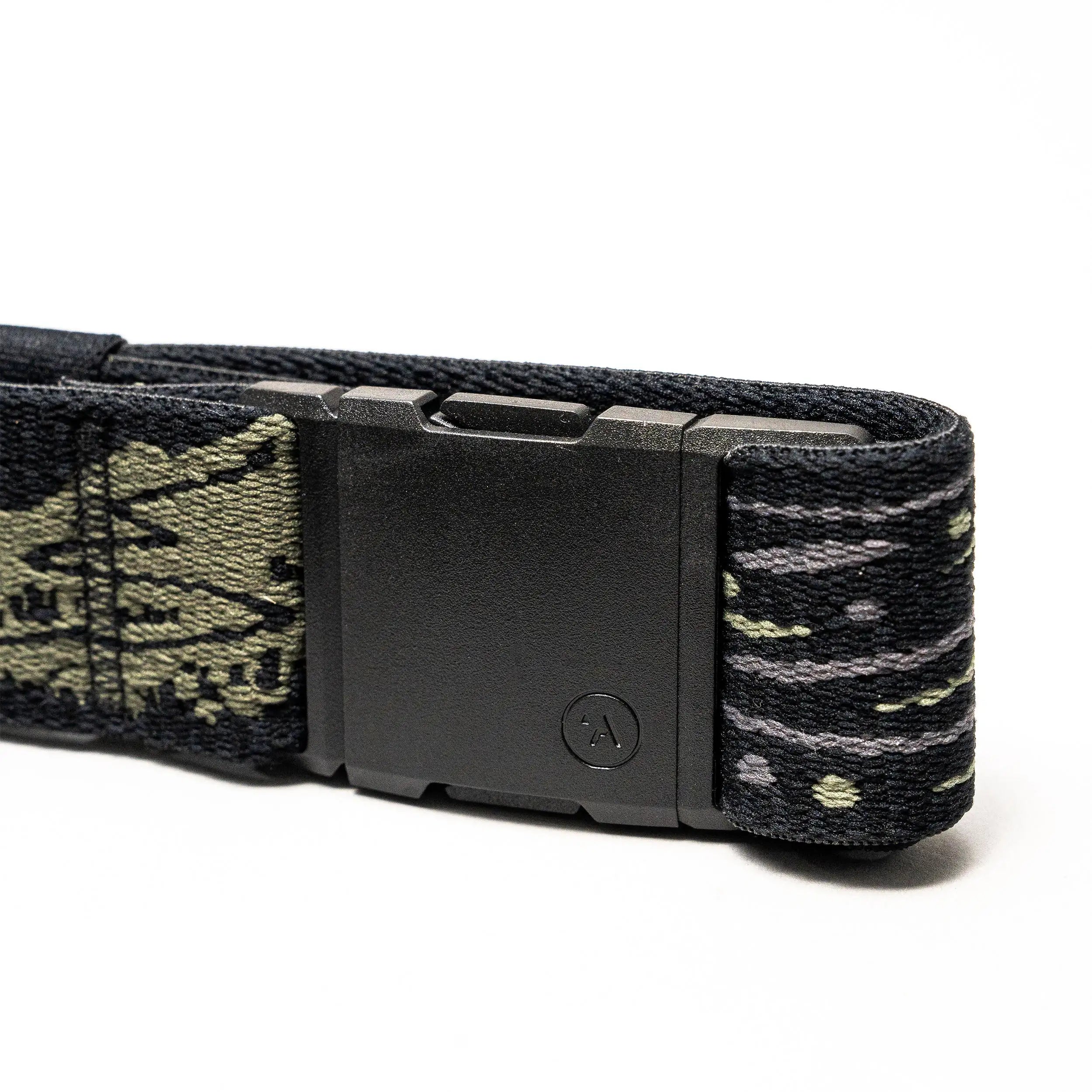 A close-up of the Arcade Belts Out of Range belt shows a black rectangular buckle and stretch webbing with a green and gray camo pattern. A small circular A logo decorates the buckle, ensuring both comfort and branded style.