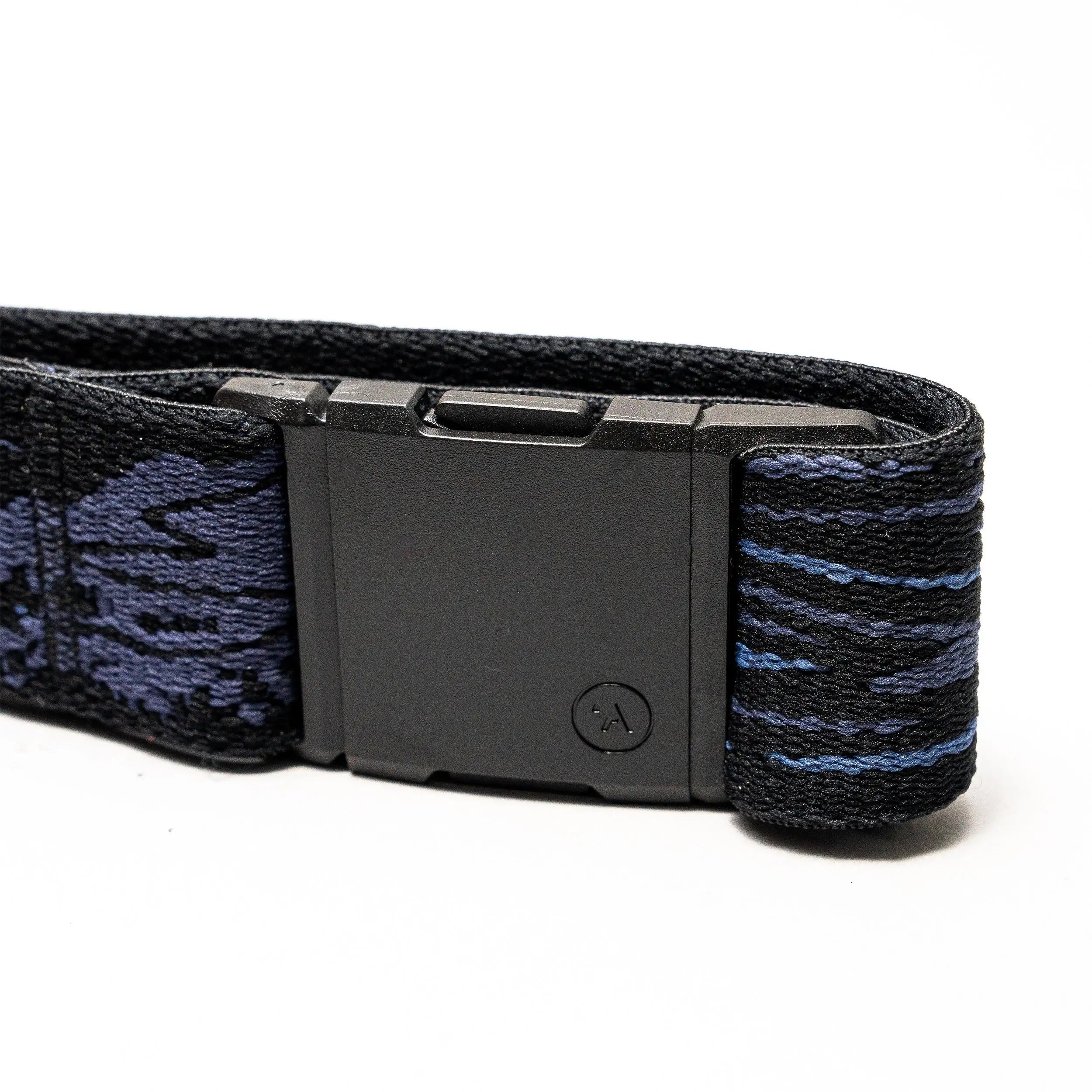 A close-up of the Arcade Belts Out of Range black plastic buckle on an elastic stretch belt with a dark blue and black patterned strap, shown against a white background.