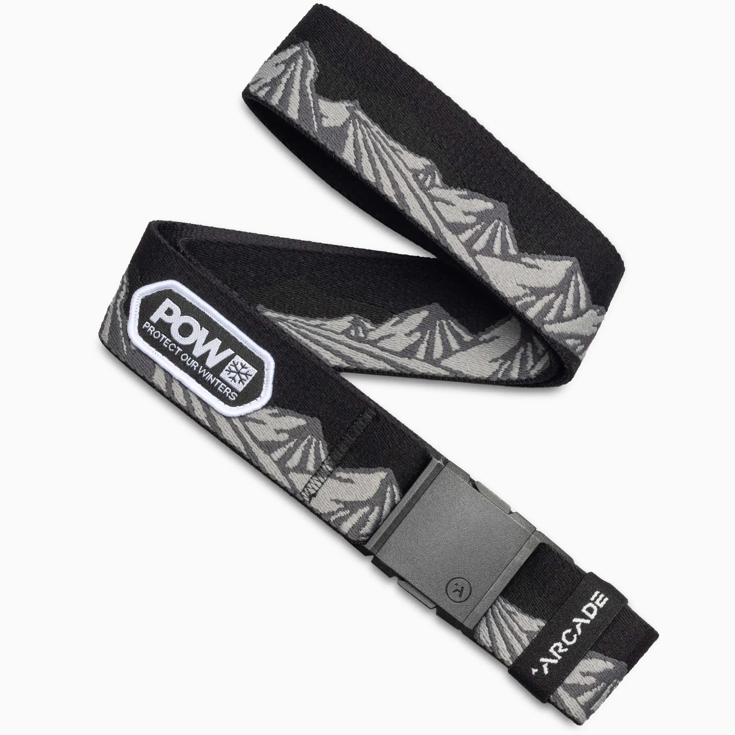 The Arcade Belts POW x Joseph Toney is a black, low-profile belt with a gray mountain design, a POW patch, durable plastic buckle, and white Arcade branding on the tip—perfect for travel belt enthusiasts.