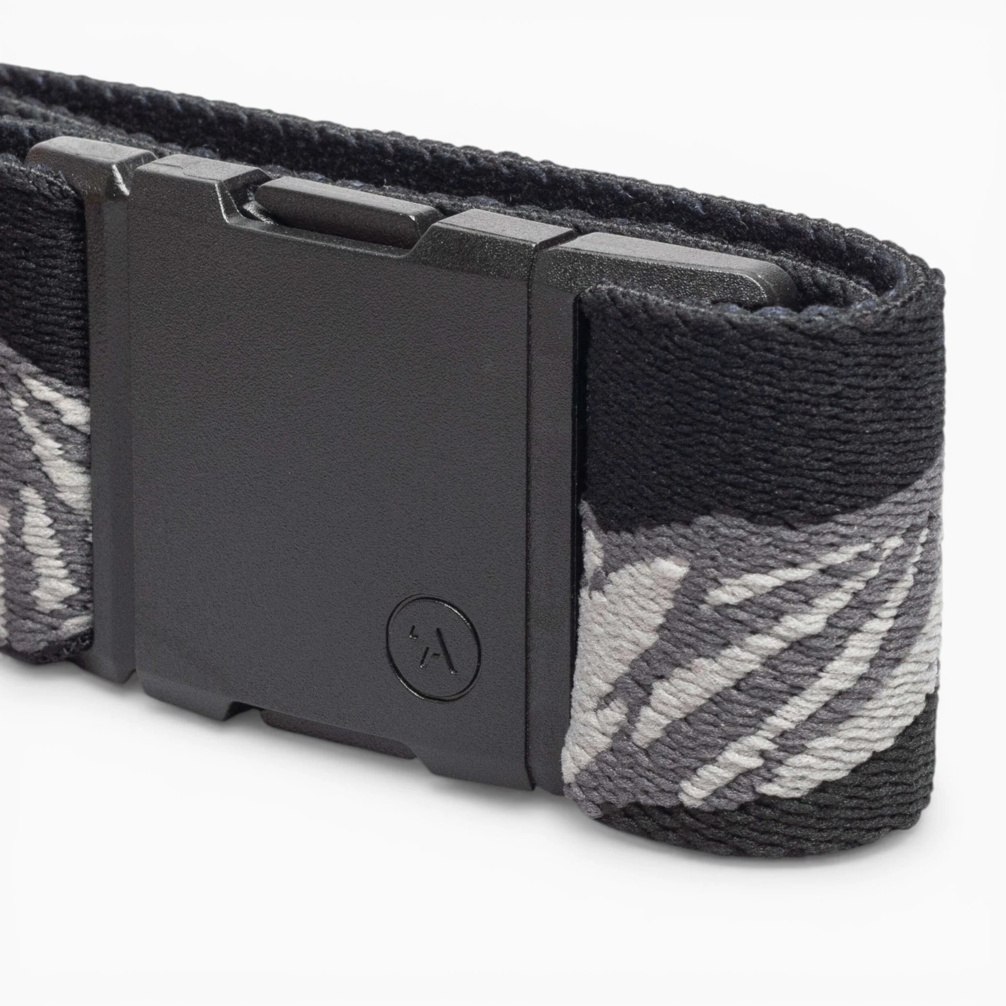 A close-up of the Arcade Belts POW x Joseph Toney, a low profile belt with a matte black rectangular plastic buckle, featuring a subtle textured pattern, small circular logo, and elastic gray and white abstract design.