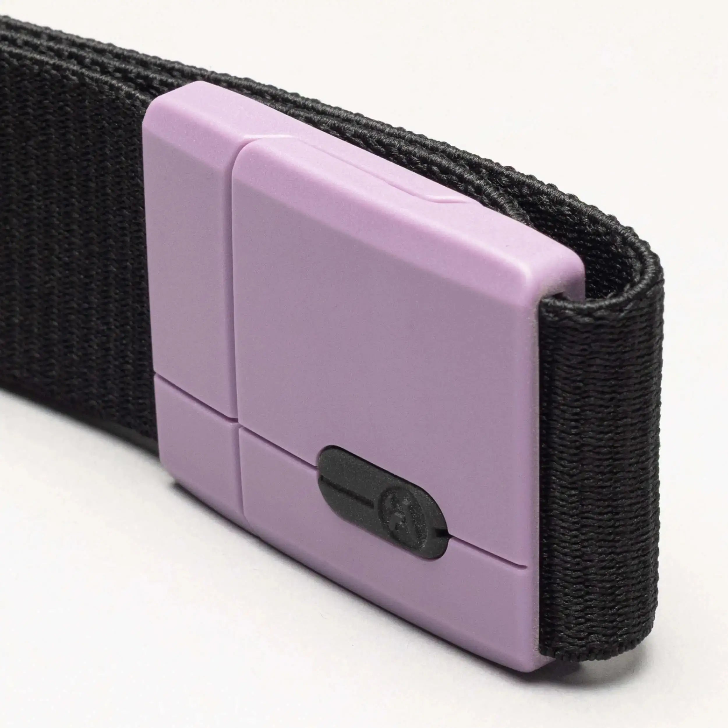 A close-up of the Arcade Belts Polar Mag: a black fabric belt with a rectangular light purple plastic buckle and small black sliding tension lock, shown against a plain, light background.