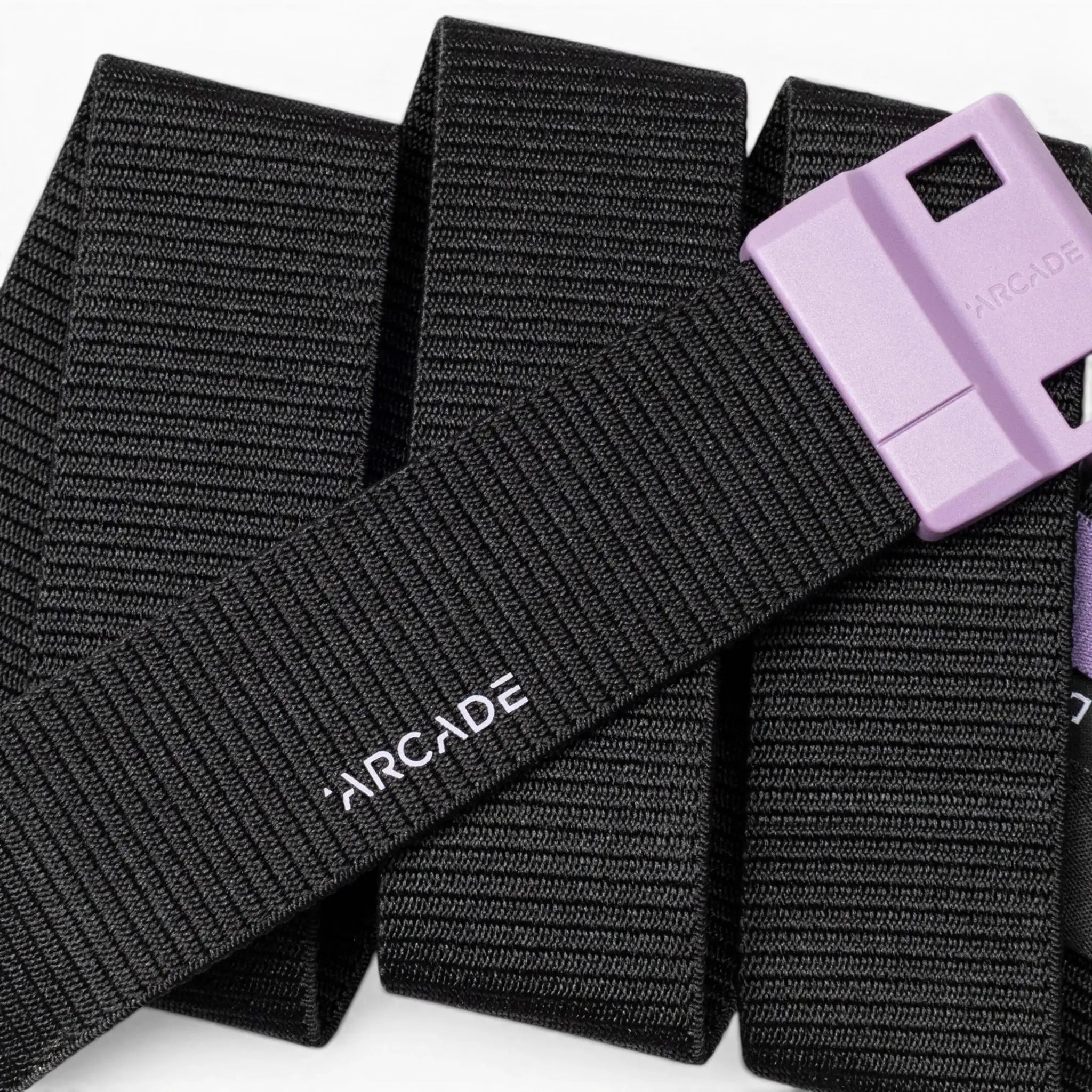 A black Arcade Belts Polar Mag belt is shown, featuring a purple plastic buckle with SwiftLock technology for easy and secure fastening, a subtle stripe texture, and the Arcade logo in white letters.