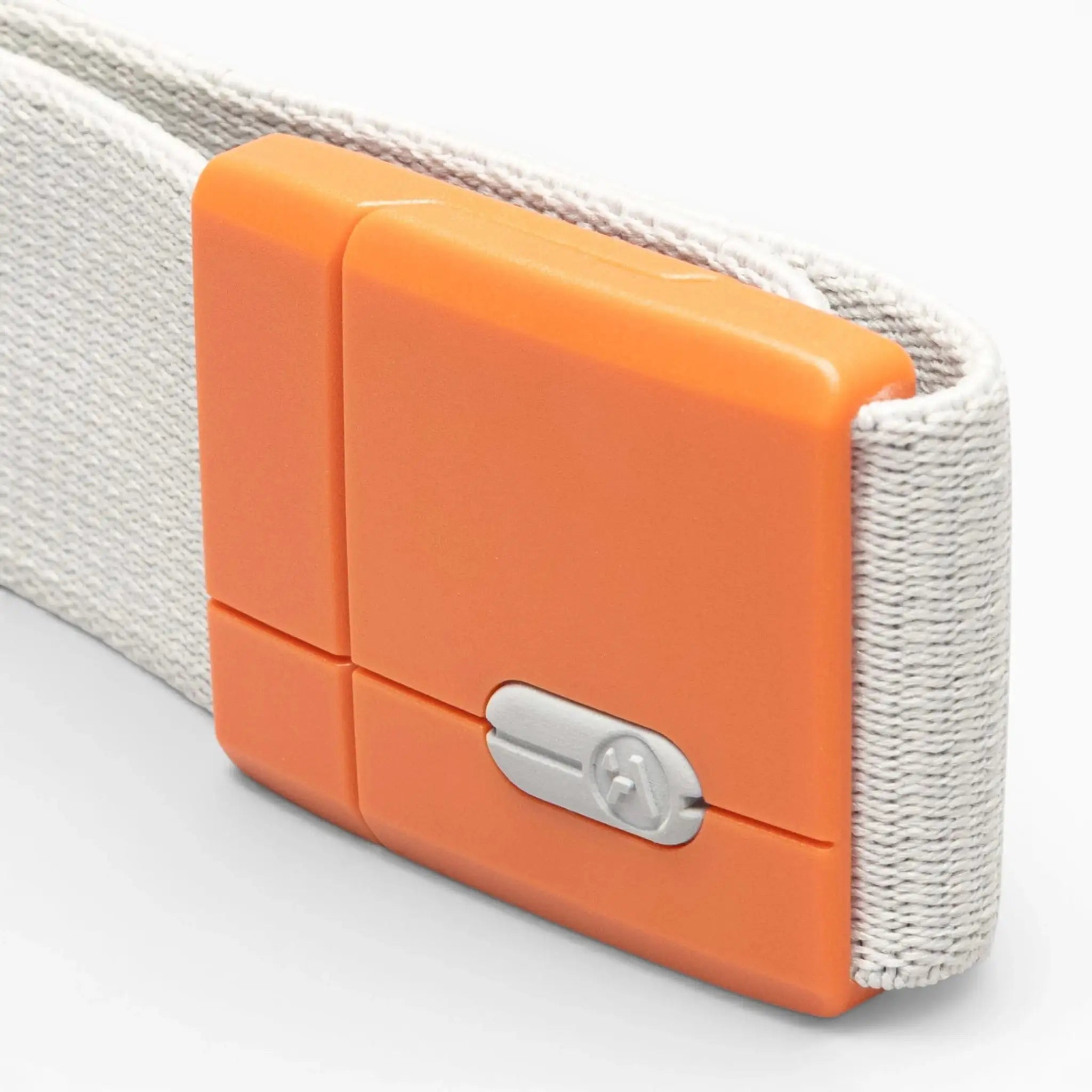 A close-up of the Polar Mag by Arcade Belts, showcasing a white fabric strap with an orange plastic buckle that features SwiftLock technology and a small silver screw in the center for added security.
