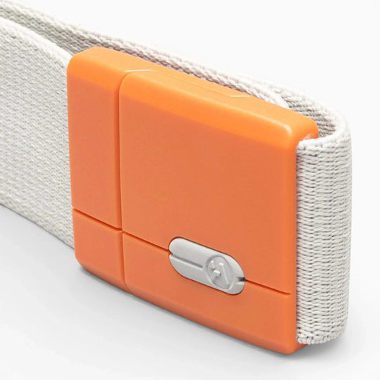 A close-up of the Polar Mag by Arcade Belts, showcasing a white fabric strap with an orange plastic buckle that features SwiftLock technology and a small silver screw in the center for added security.