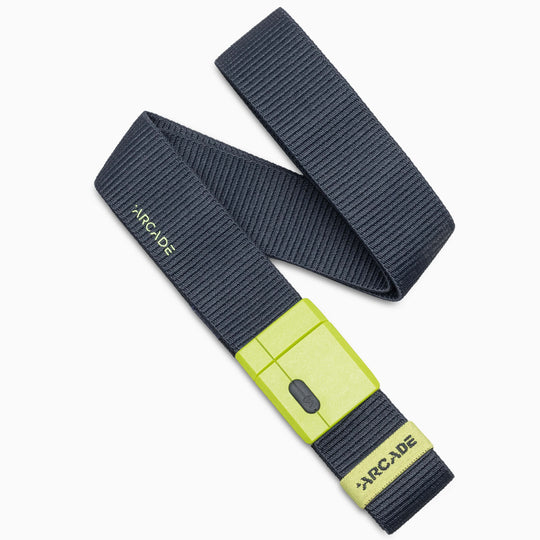 A dark gray, ribbed stretch Mag Kit II belt from Arcade Belts featuring a bright yellow-green SwiftLock buckle and Arcade branding on both the buckle and the belt. Inspired by Adventure Mag belts, it is arranged in a loose, overlapping loop.