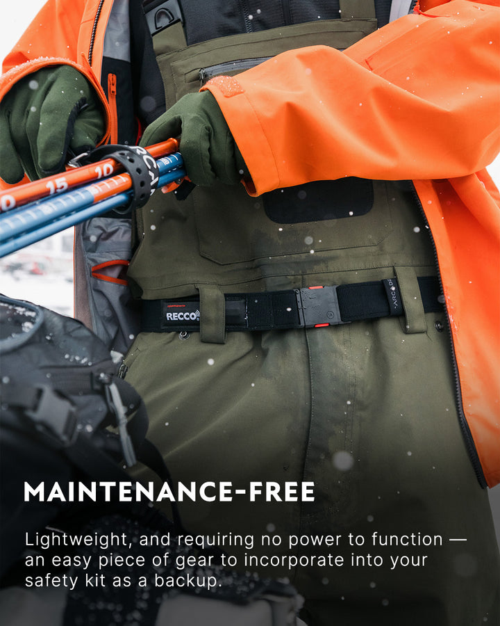 A person wearing an orange jacket and green overalls adjusts ski poles, with gear strapped around their waist. Text below reads: Maintenance-Free. Lightweight, and requiring no power to function—an easy piece of gear to incorporate into your safety kit as a backup.