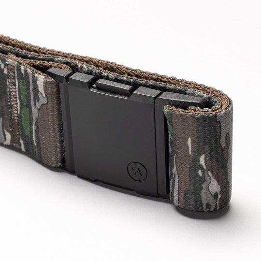 A close-up of the Arcade Belts Realtree Camo Original, featuring stretch webbing and a matte black rectangular buckle, displayed on a white background.