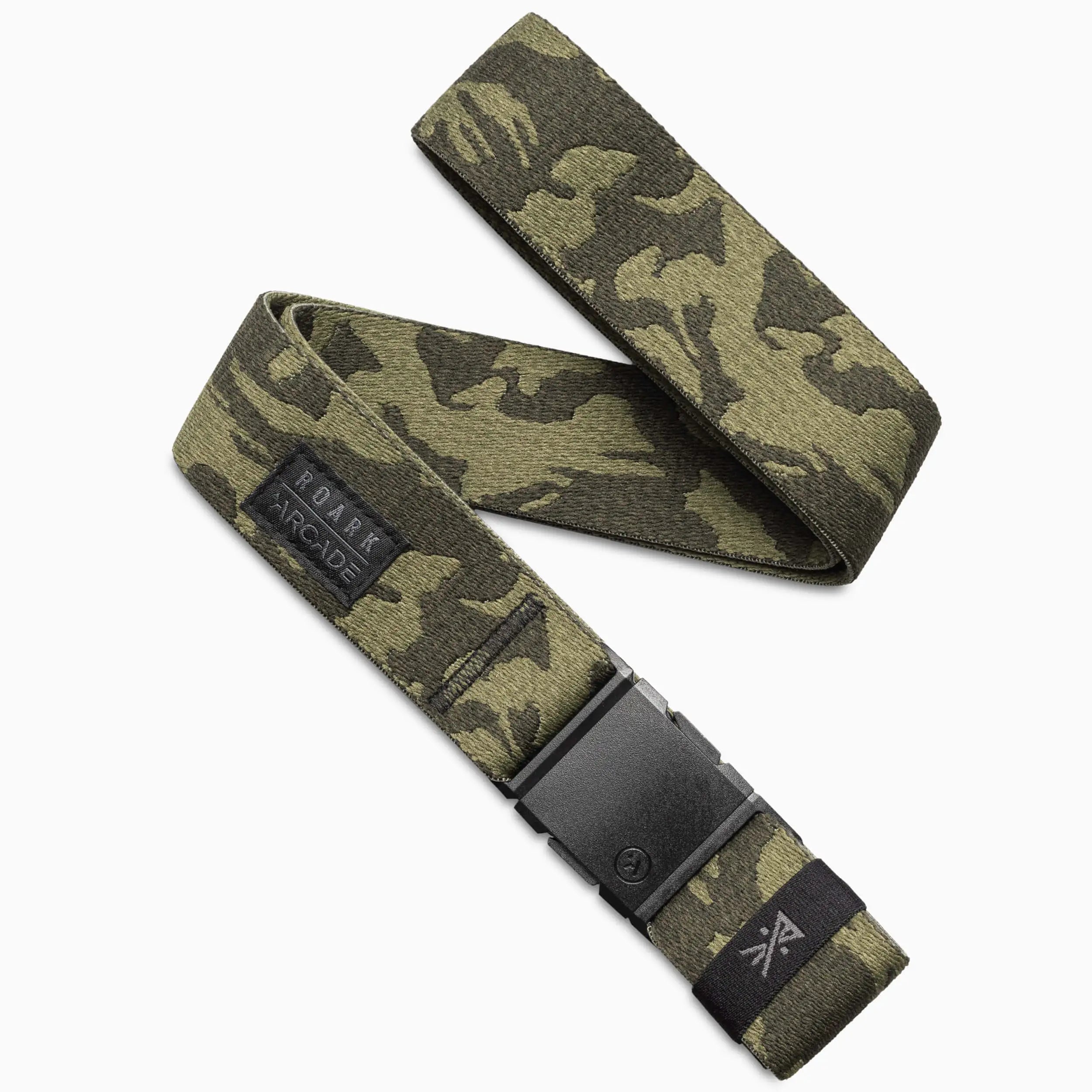The Arcade Belts Roark x Arcade adventure belt in camo features performance stretch, a black plastic buckle, and a small “Roark Arcade” logo tag on one end, shown against a white background.