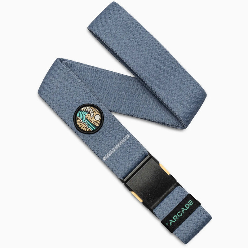 The Arcade Belts Save the Waves belt in Sky features a surf-inspired patch, black buckle, and green ARCADE branding, supporting conservation efforts like Save the Waves.