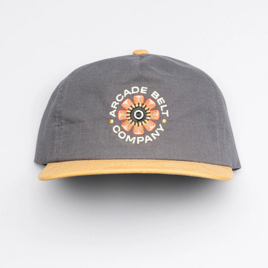 The Arcade Semi Structured Hat by Arcade Belts is a gray cap with a yellow brim and embroidered flower design, plus ARCADE BELT COMPANY on the front—ideal to pair with your favorite low profile belt.