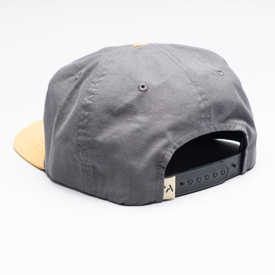 The Arcade Semi Structured Hat by Arcade Belts features a gray crown, yellow brim, adjustable black snapback, metal eyelets for ventilation, and stretch webbing inspired by Arcade Belts for enhanced comfort. Shown from the back.