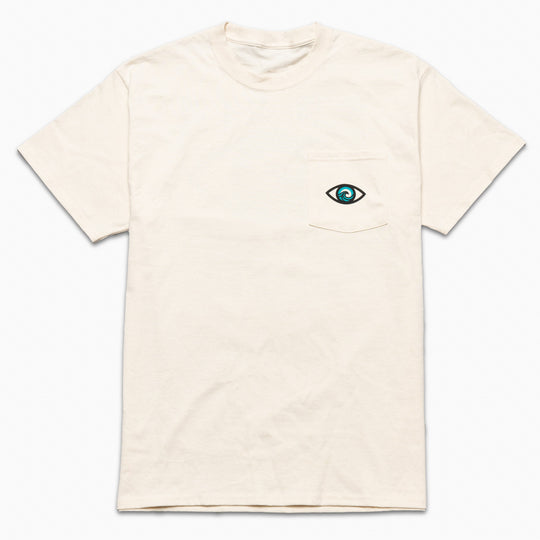 The Arcade Freedom Tee by Arcade Belts is a plain off-white shirt with a small chest pocket featuring an embroidered blue and black eye, perfect for pairing with travel belts or stretch webbing accessories.