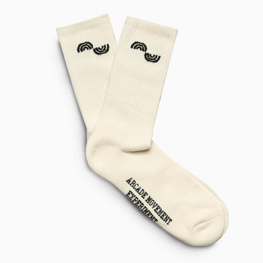 Arcade Movement Experiment Socks by Arcade Belts: off-white socks with black semicircle accents near the top and “ARCADE MOVEMENT EXPERIMENT” printed in black on the sole, inspired by Arcade Belts’ signature style.