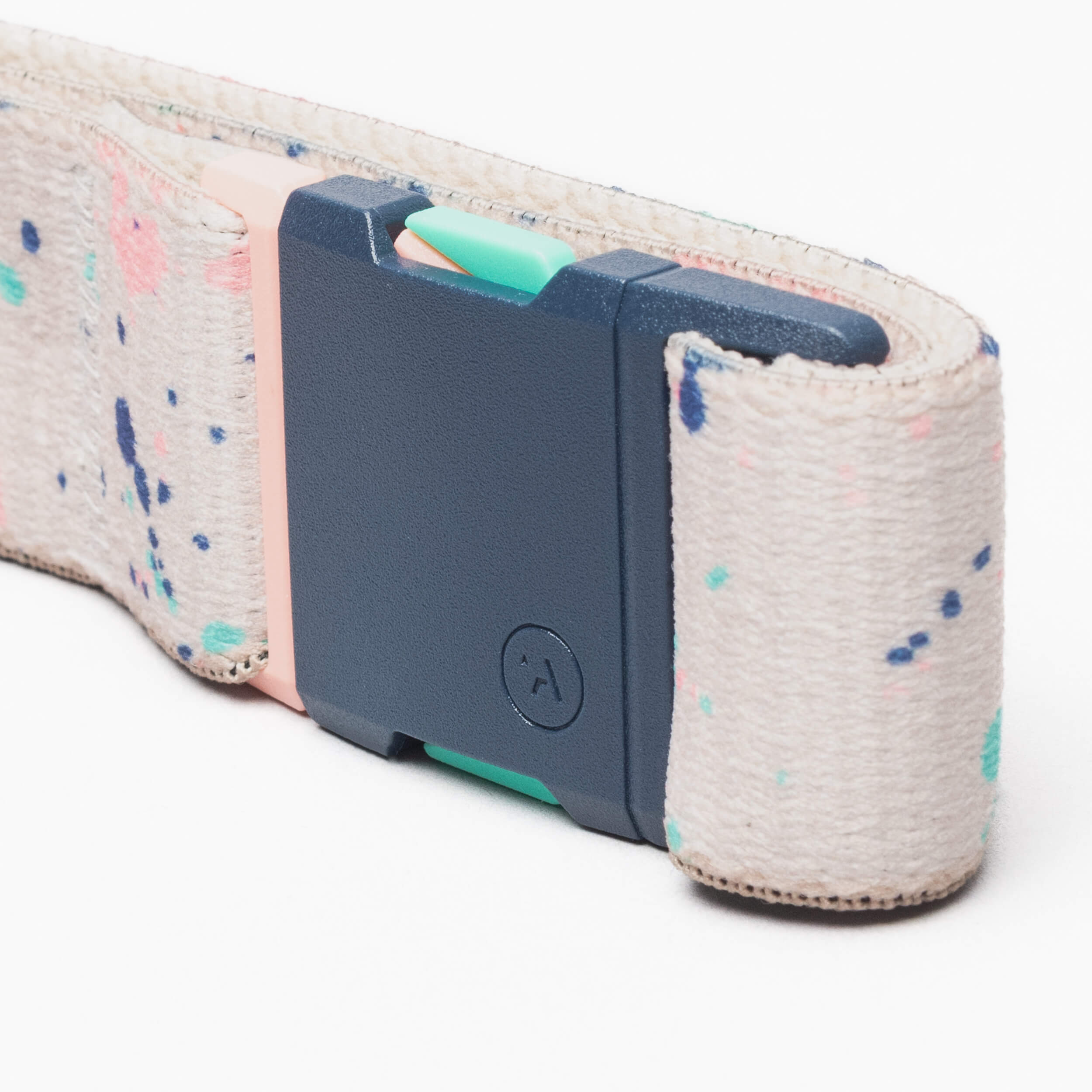 A close-up of the Splatter belt by Arcade Belts, featuring a colorful splatter pattern and a rectangular plastic buckle in navy blue, pale pink, and mint green.