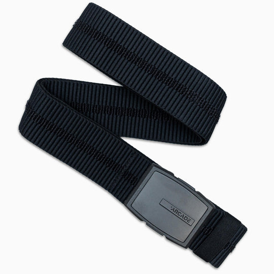 The Stamped belt by Arcade Belts is a black, adjustable elastic stretch belt with a subtle horizontal stitched texture and a rectangular black plastic buckle engraved with ARCADE—perfect as your go-to travel accessory.