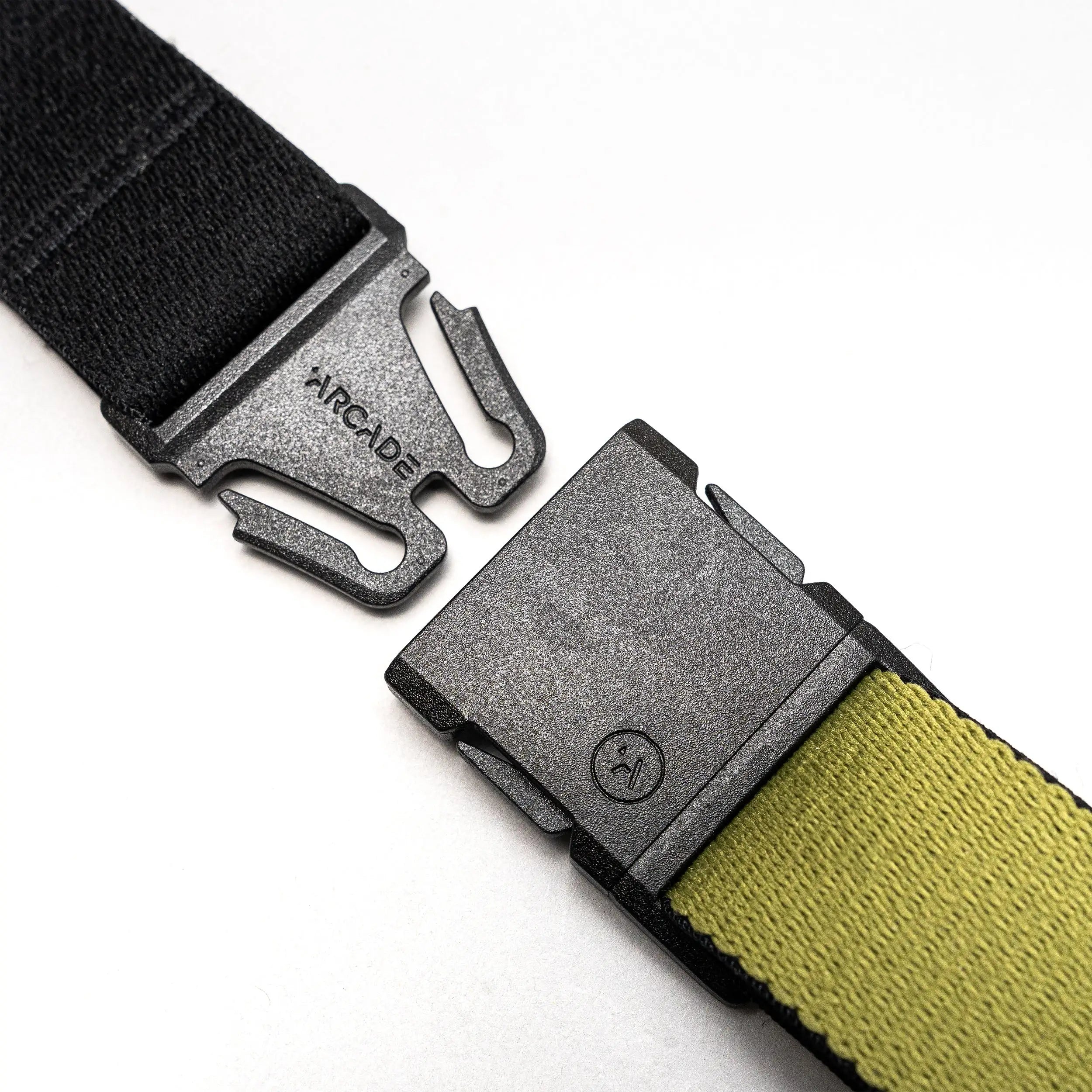 Close-up of the Arcade Belts Static Youth in black and olive green, featuring a metal quick-release buckle engraved with ARCADE, shown unbuckled on a white background.