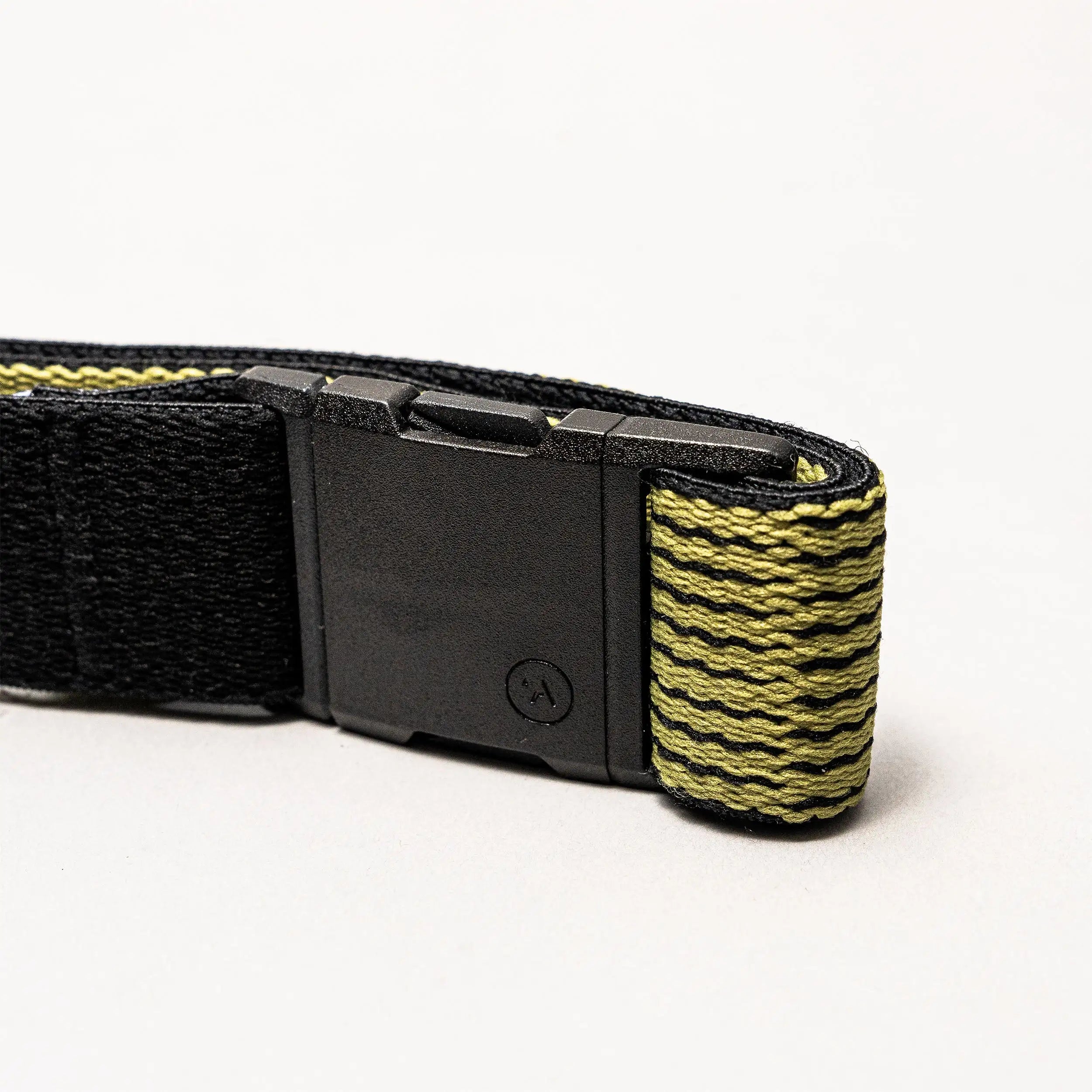 A close-up of the Arcade Belts Static Youth, a black and yellow stretch webbing strap with a black plastic buckle, shown against a plain white background.