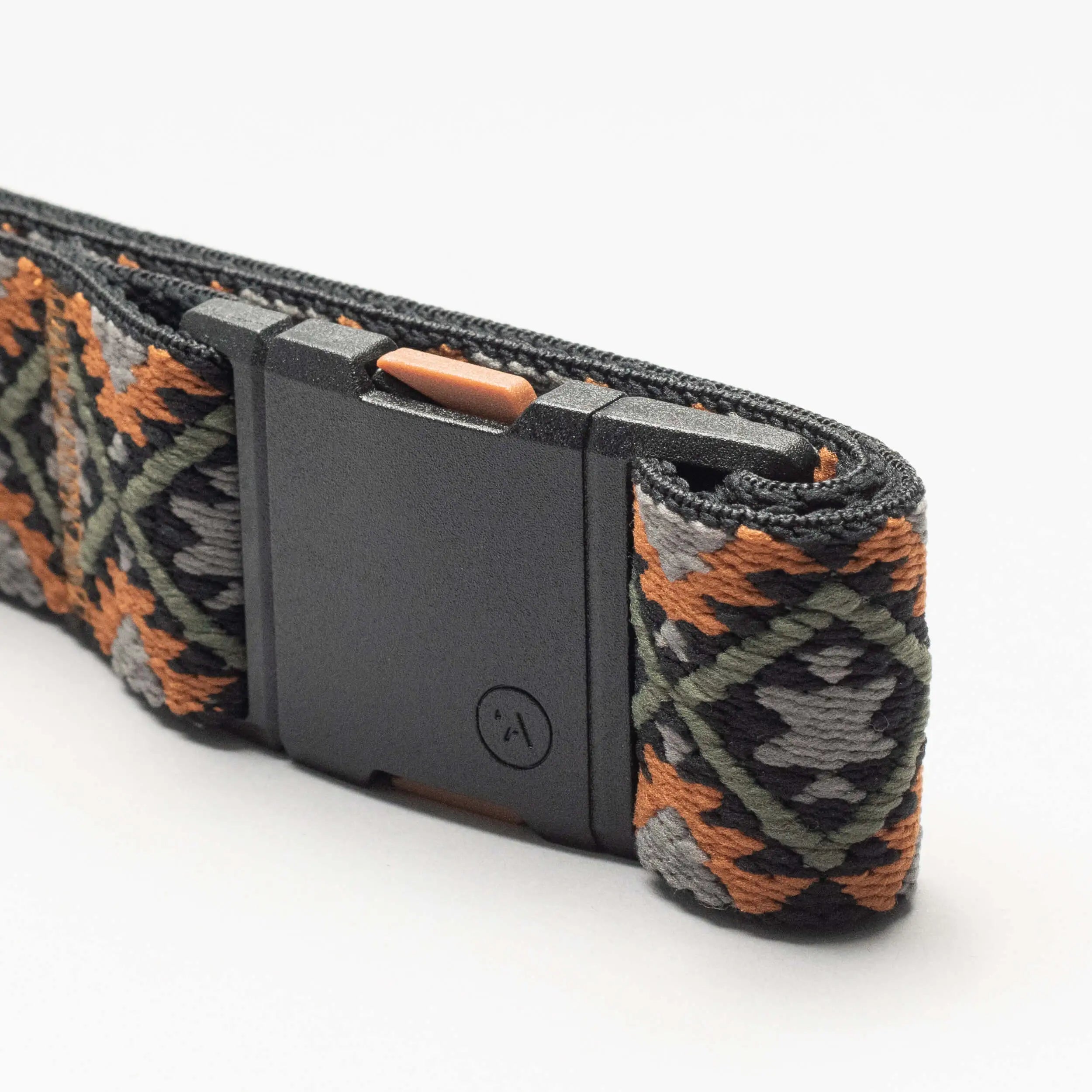 The Arcade Belts Vernan Kee is a stretch webbing belt with a black plastic buckle and an orange, green, gray, and black diamond design—ideal as a low-profile travel accessory.