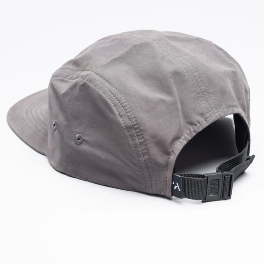 The Arcade Camp Hat by Arcade Belts is shown from the back, featuring a gray, five-panel design with a black adjustable strap and side ventilation eyelets. The versatile hat rests on a white surface.
