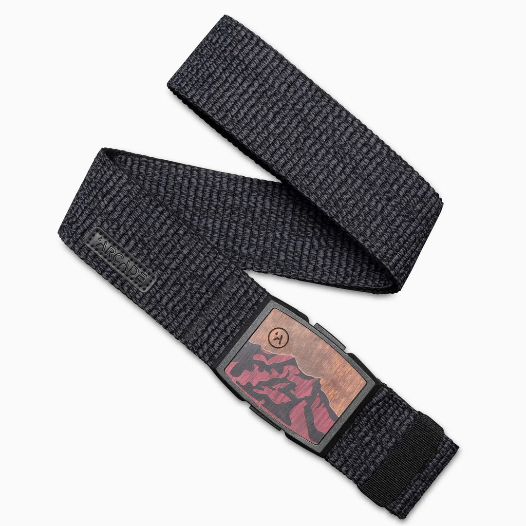 The Woody by Arcade Belts is a black woven travel belt featuring a durable plastic buckle and a vibrant red and brown mountain landscape design—ideal for everyday adventures.