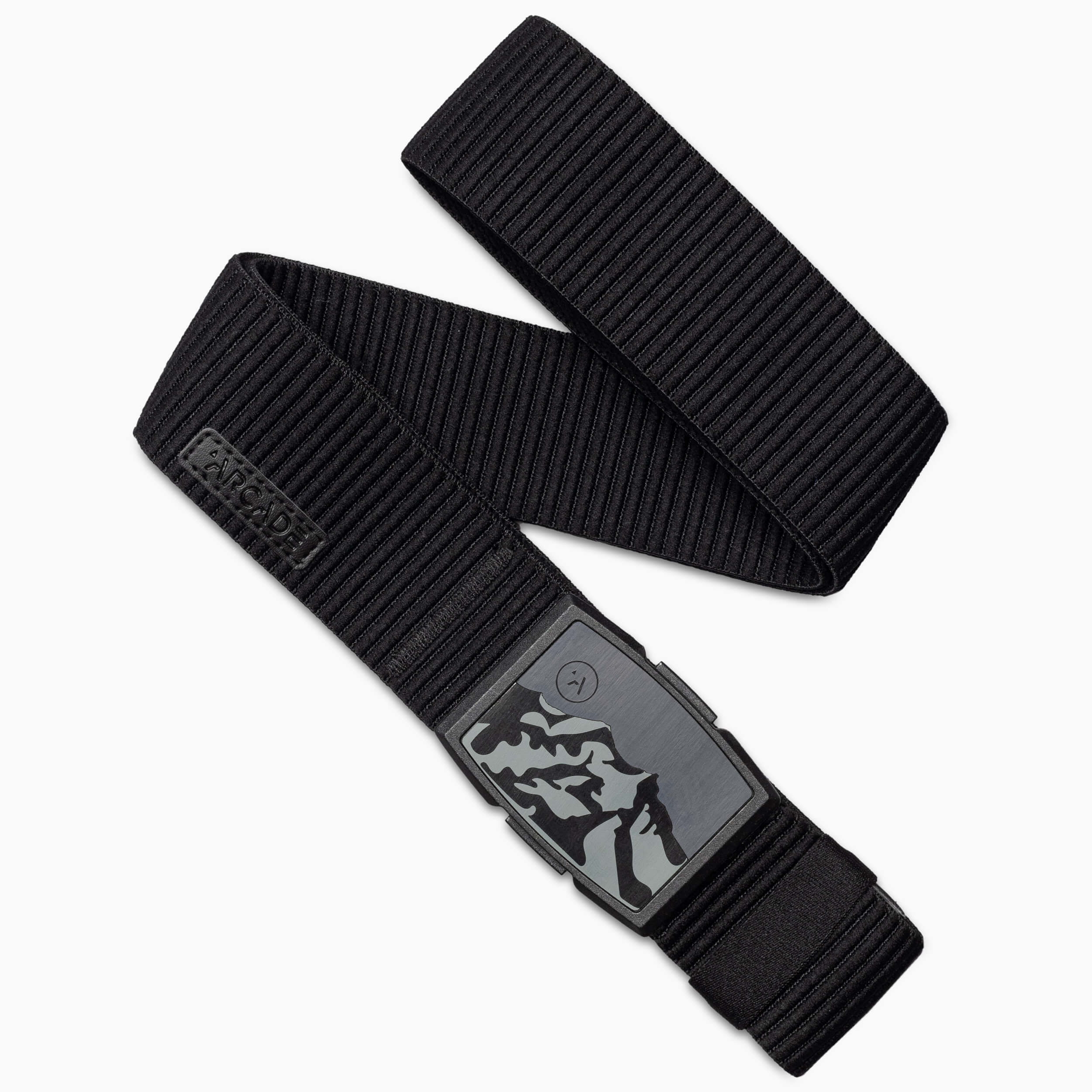 The Arcade Belts Woody Kit is a black elastic stretch armband with a rectangular buckle featuring a mountain design, highlighting the brand’s signature craftsmanship and travel-ready style.