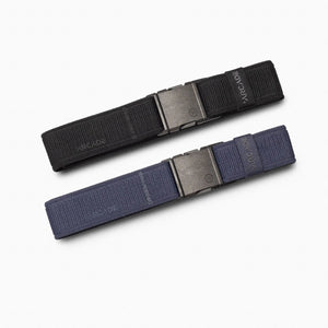The A2 Youth Kit by Arcade Belts features two fabric belts, one black and one navy blue, each with a rectangular metal buckle and machine-washable design—perfect for kids’ climbing gear.