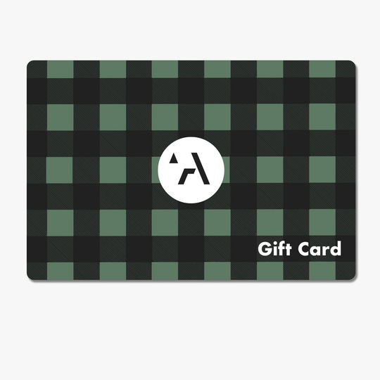 The Arcade Belts Gift Card features a green and black checkered pattern inspired by stretch webbing, a white circle with a stylized A in the center, and “Gift Card” in white text at the bottom right.