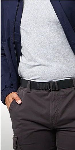 A person wearing a light gray t-shirt, dark blue jacket, dark gray cargo pants, and a black belt with one hand in their pocket.